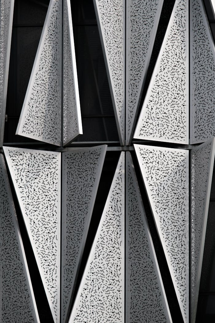 Close-up of contemporary geometric aluminum facade with textured tiles.